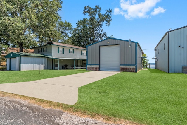 view of front of property featuring an outbuilding, a garage, and a front yard