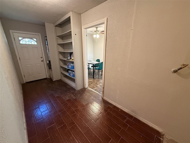 foyer entrance with dark hardwood / wood-style floors and a textured ceiling