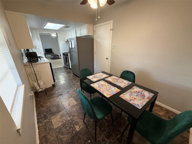 dining room with a skylight and ceiling fan