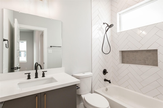 full bathroom featuring tiled shower / bath, plenty of natural light, vanity, and toilet