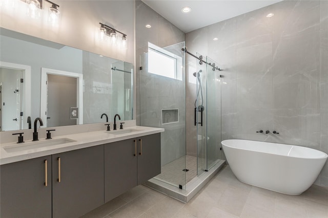 bathroom with tile patterned flooring, plus walk in shower, tile walls, and vanity