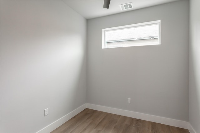 empty room with ceiling fan and light hardwood / wood-style flooring