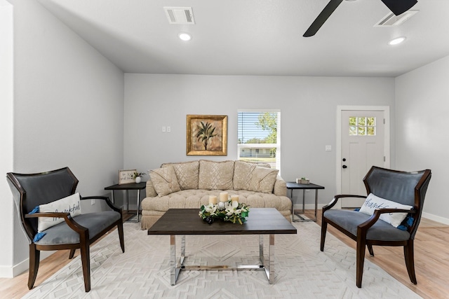 living room with ceiling fan and light hardwood / wood-style flooring