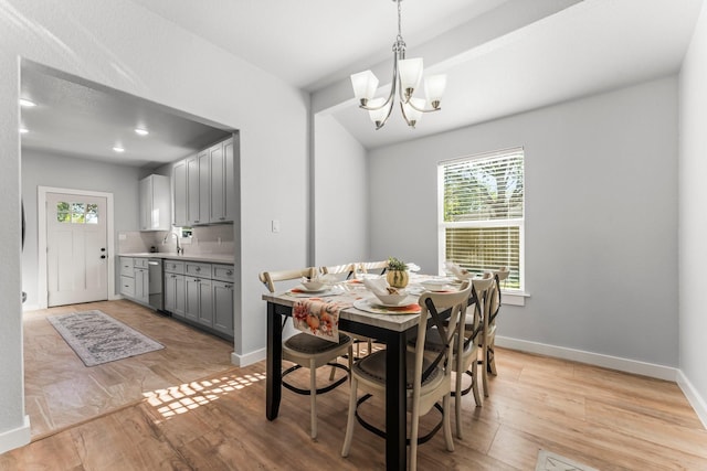 dining room featuring sink, a chandelier, and light wood-type flooring