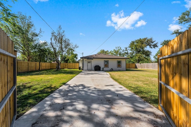 rear view of property featuring a yard and a patio area