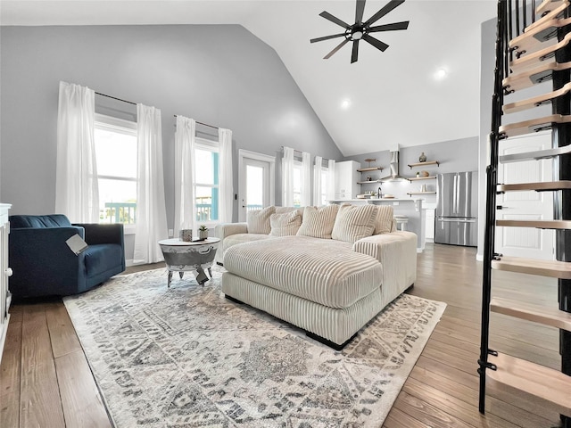 bedroom featuring hardwood / wood-style flooring, stainless steel fridge, and high vaulted ceiling