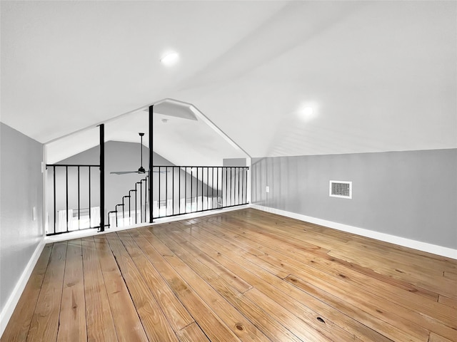 additional living space with hardwood / wood-style flooring, lofted ceiling, and ceiling fan