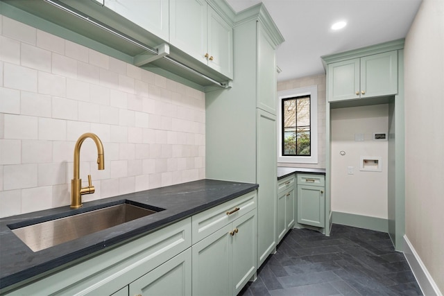 kitchen with tasteful backsplash, sink, dark stone counters, and green cabinets