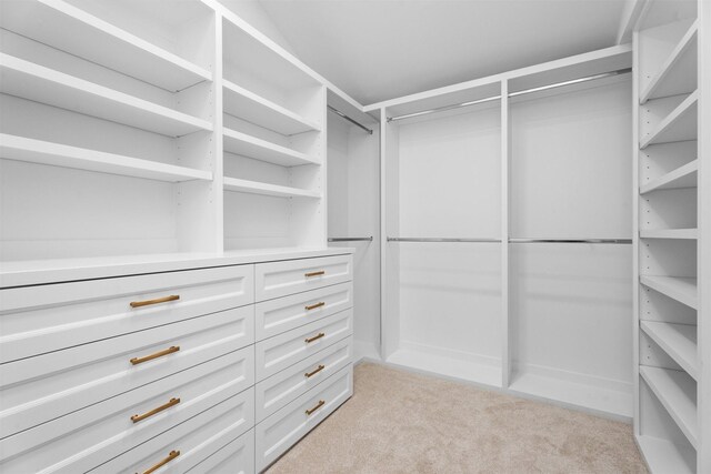 walk in closet featuring light colored carpet