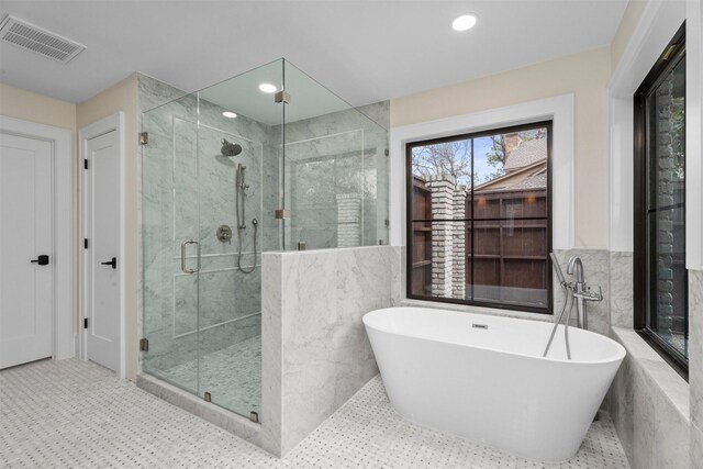 bathroom with tile walls and independent shower and bath