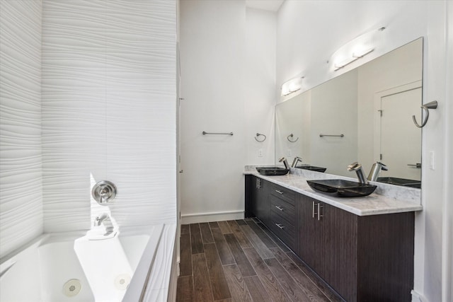 bathroom featuring a bathing tub, wood-type flooring, and vanity