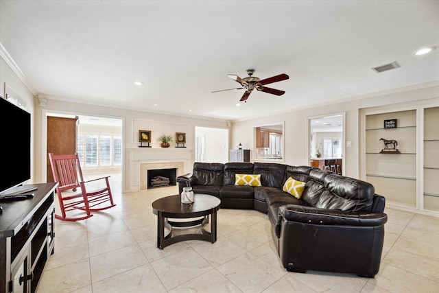 living room featuring crown molding, ceiling fan, and built in features