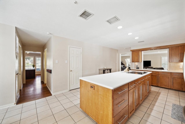 kitchen with sink, a center island with sink, and light tile patterned floors