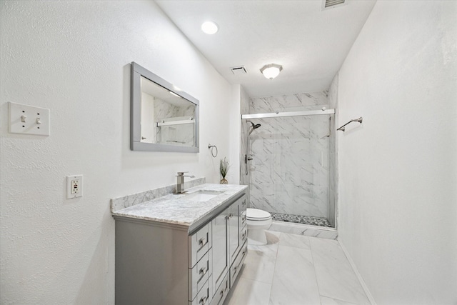 bathroom with vanity, toilet, and a shower with shower door