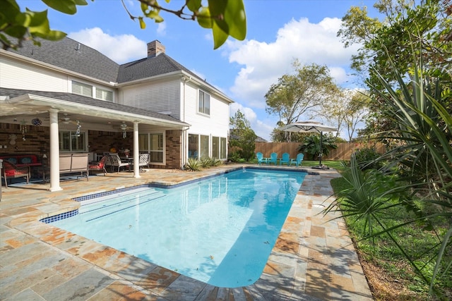 view of swimming pool with ceiling fan and a patio area