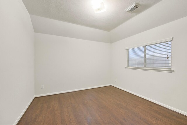 unfurnished room with dark wood-type flooring and a textured ceiling