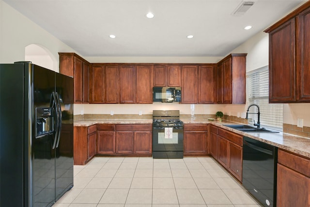 kitchen with light tile patterned floors, light stone countertops, sink, and black appliances