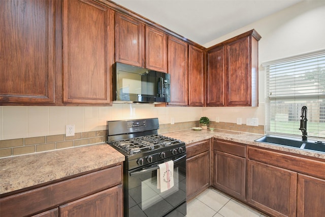 kitchen featuring tasteful backsplash, light countertops, a sink, and black appliances