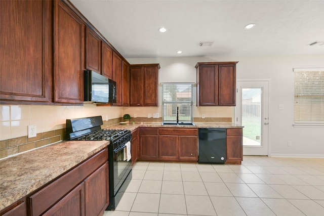 kitchen featuring light stone counters, light tile patterned floors, visible vents, a sink, and black appliances