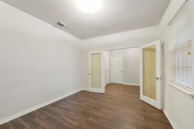 spare room with a textured ceiling and french doors