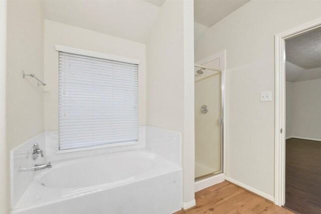 bathroom featuring shower with separate bathtub and wood-type flooring