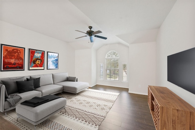 living area featuring baseboards, a ceiling fan, vaulted ceiling, and dark wood-type flooring