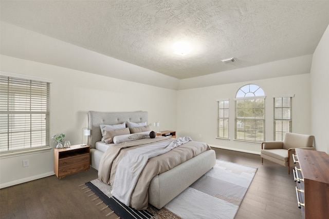 bedroom featuring dark wood-style flooring, visible vents, and multiple windows