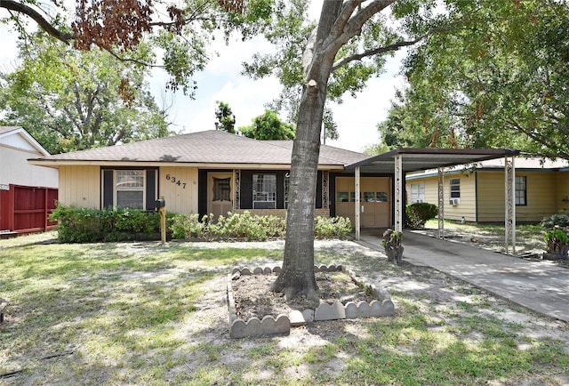 ranch-style home featuring a front lawn and a carport