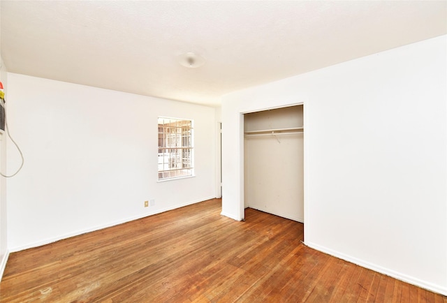 unfurnished bedroom featuring hardwood / wood-style flooring and a closet