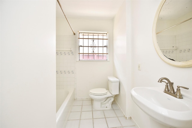 full bathroom with tiled shower / bath, toilet, tile patterned flooring, and sink