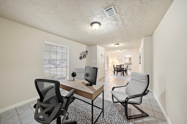 tiled office space featuring a textured ceiling