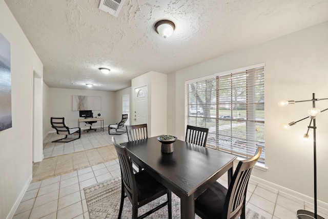 dining room with light tile patterned floors and a textured ceiling