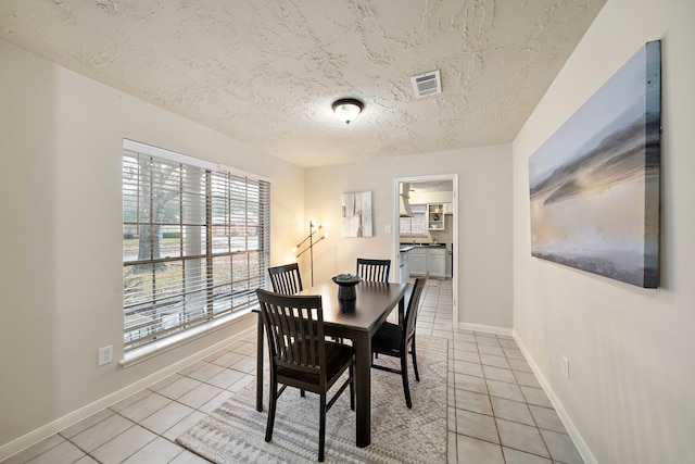 tiled dining space with a textured ceiling