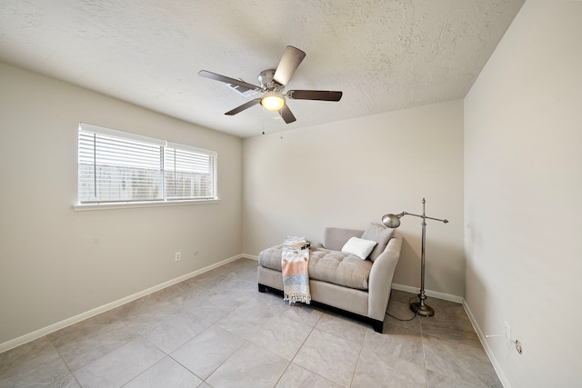 sitting room featuring ceiling fan and a textured ceiling