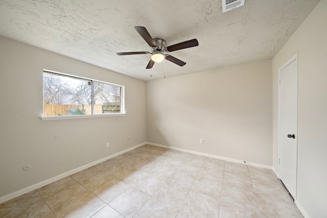 tiled empty room featuring ceiling fan and a textured ceiling