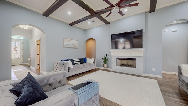 living room featuring coffered ceiling, hardwood / wood-style floors, beam ceiling, and a premium fireplace