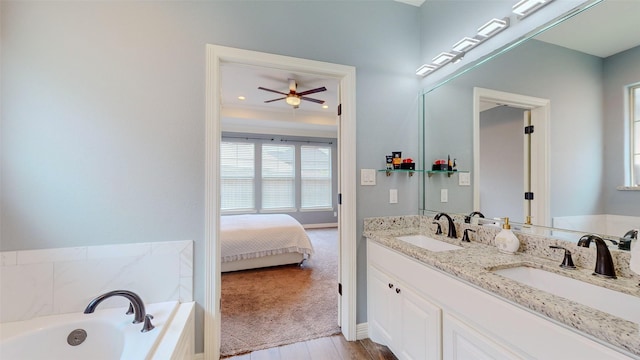 bathroom with a bath, vanity, hardwood / wood-style floors, and ceiling fan