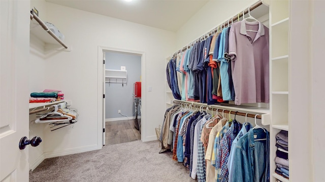 spacious closet with washer and dryer and light carpet