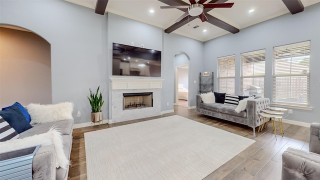 living room featuring ceiling fan, beam ceiling, coffered ceiling, wood-type flooring, and a high end fireplace