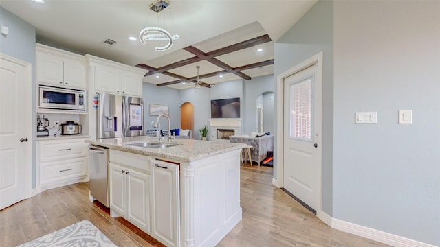 kitchen with an island with sink, sink, white cabinets, coffered ceiling, and stainless steel appliances