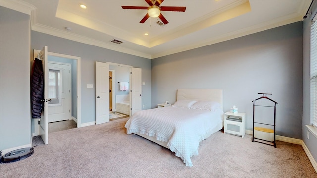 carpeted bedroom with crown molding, connected bathroom, and a tray ceiling