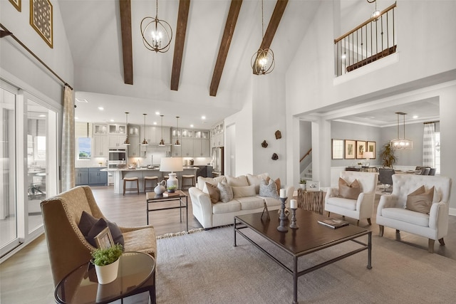 living room featuring beamed ceiling, a chandelier, and high vaulted ceiling