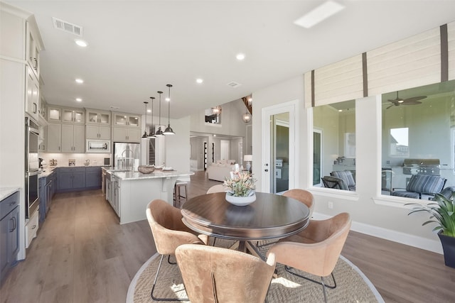 dining area with ceiling fan, sink, and hardwood / wood-style floors