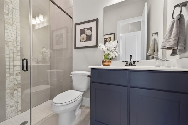 bathroom featuring a shower with door, vanity, and toilet