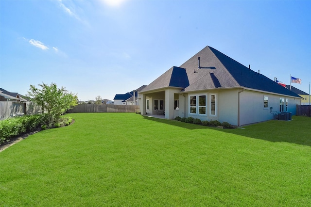 back of house with a yard and central AC unit