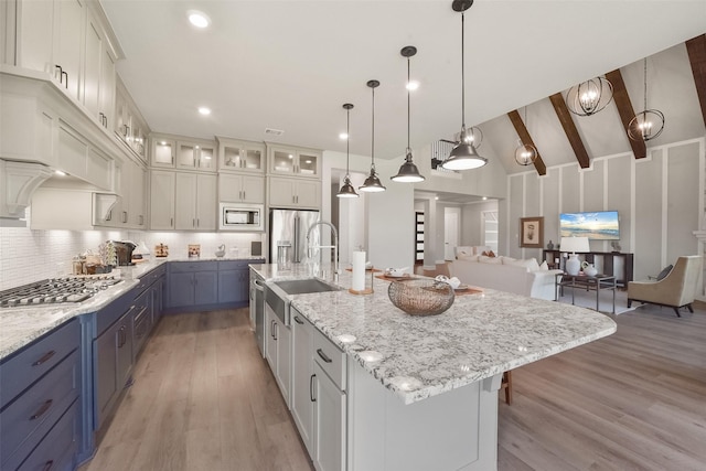 kitchen featuring white cabinetry, appliances with stainless steel finishes, a large island, and hanging light fixtures