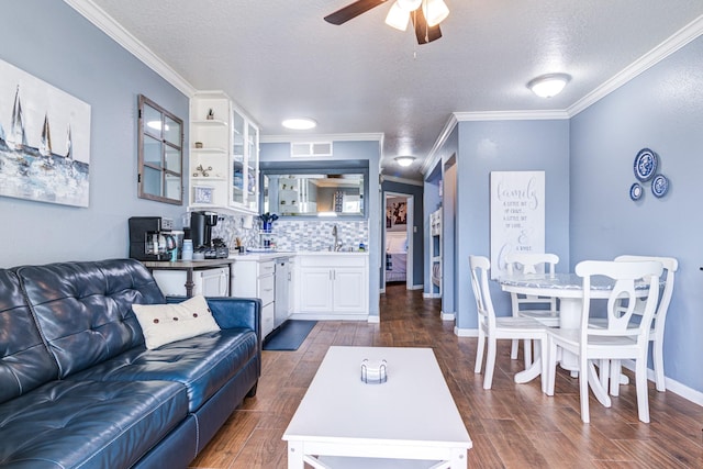 living room featuring ornamental molding, dark wood-type flooring, wet bar, and a textured ceiling