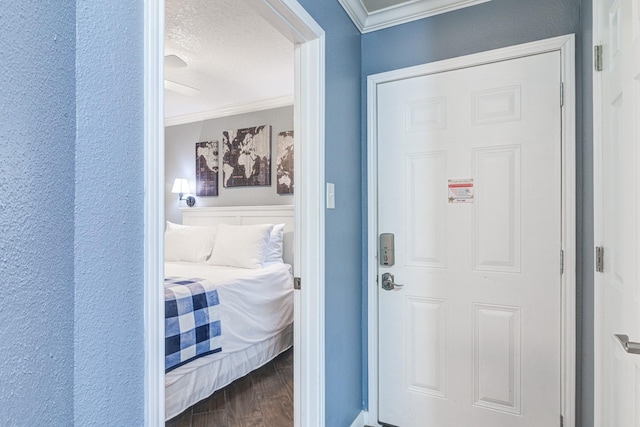 doorway to outside with hardwood / wood-style flooring, ornamental molding, and a textured ceiling