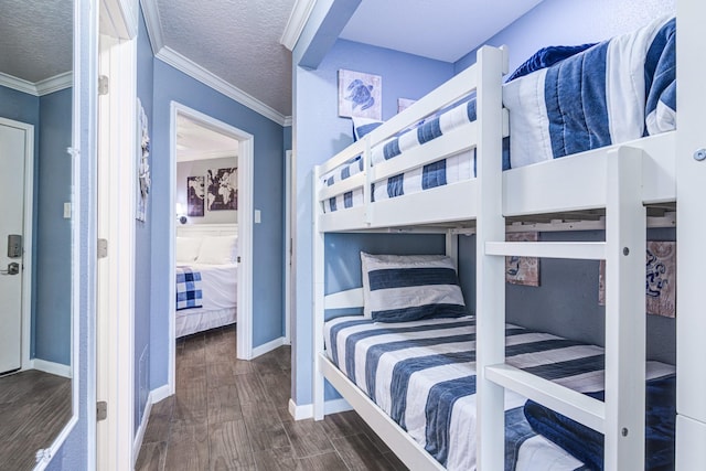 bedroom with ornamental molding, a textured ceiling, and dark hardwood / wood-style flooring