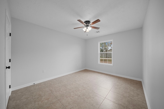 tiled spare room with ceiling fan and a textured ceiling